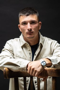 Young successful stylish man. Classical portrait of a businessman dressed in a jacket with a watch on his hand.