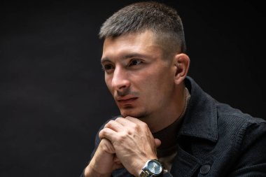 Genç, başarılı, şık bir adam. Ceket giymiş ve elinde saat olan bir iş adamının klasik portresi..