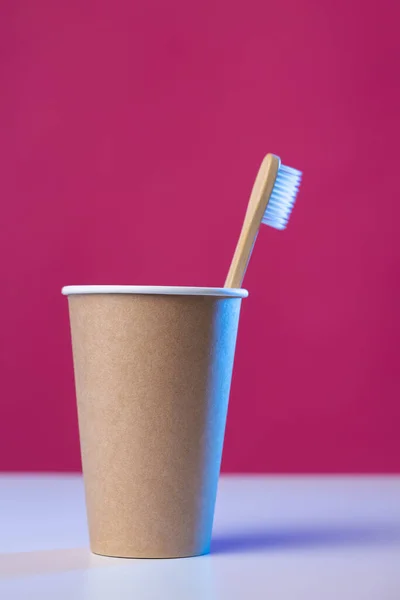 Toothbrush in a cardboard ecological cardboard cup, hygiene health care.