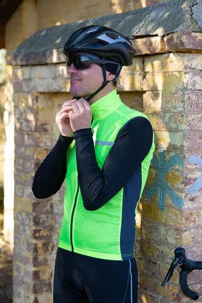 A man in clothes stands with a bicycle on an autumn sunny day. Cyclist in an urban environment.