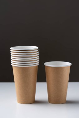 Disposable cardboard biodegradable cups on a white table, gray background.