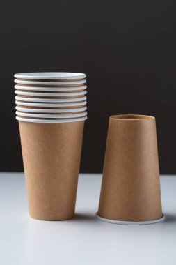 Disposable cardboard biodegradable cups on a white table, gray background.