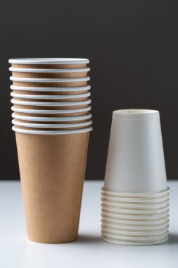 Disposable cardboard biodegradable cups on a white table, gray background.