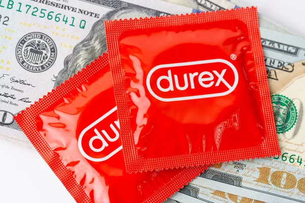 Kırmızı bir Durex prezervatif paketi ve dolar banknotları..