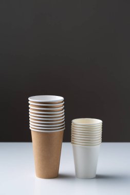 Disposable cardboard biodegradable cups on a white table, gray background.