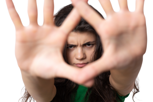 Avuç içi beyaz arka planda, dur hareketi gösteren ciddi bir genç kadının portresi.