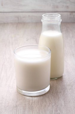 milk and glass of white and fresh dairy products on wooden background