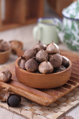 fresh organic garlic in a bowl on wooden table