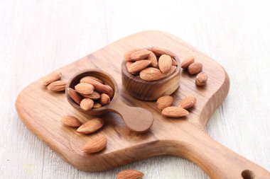 almonds in wooden bowl on white table