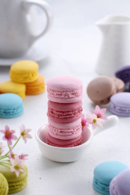 Açık arkaplan üzerinde beyaz ve sarı badem kurabiyeleri olan pembe kurabiyeler..