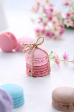 Beyaz arka planda badem kurabiyeleri ve pembe makaronlar.