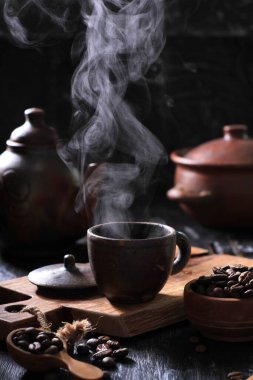 Koyu kahve ve bir fincan çay ahşap masada.