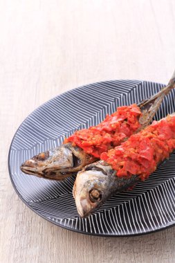 grilled fish on a plate with a knife and a red background