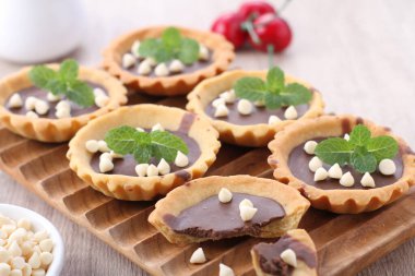 delicious chocolate muffins with berries and mint on wooden background