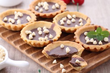 chocolate muffins with berries and mint on wooden background