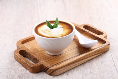 bowl of tasty mashed potato soup with parsley on wooden background