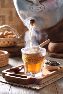 Tea is an aromatic beverage prepared by pouring hot or boiling water over cured or fresh leaves of Camellia sinensis, an evergreen shrub native to East Asia which probably originated in the borderlands of southwestern China and northern Myanmar.