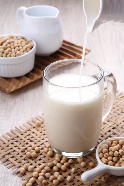 soy milk, barley, peanuts, and white beans on a wooden background