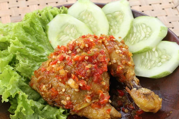 Ayam Penyet是印度尼西亚的一种炸鸡汤 由油炸鸡块和砂浆一起碎 使其更软 并配上砂锅 黄瓜片 炸豆腐和青豆 — 图库照片