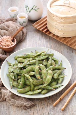 Edamame is Japanese dish and prepared of immature soybeans in the pod. The pods are boiled or steamed and may be served with salt or other condiments. Nowadays it became to be so popular in the world