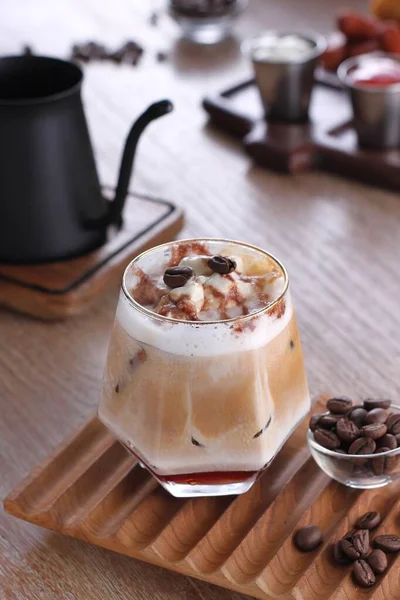 a glass of hot coffee with ice-covered with cinnamon