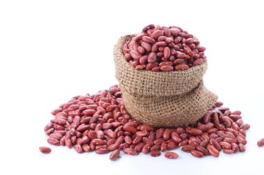 Beyaz arka planda tahtadan bir kasede kırmızı fasulye.