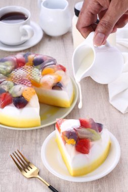 Bir parça kek, bir fincan çay ve beyaz tabakta bir limon.