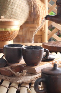 Tea is an aromatic beverage prepared by pouring hot or boiling water over cured or fresh leaves of Camellia sinensis, an evergreen shrub native to East Asia which probably originated in the borderlands of southwestern China and northern Myanmar. 