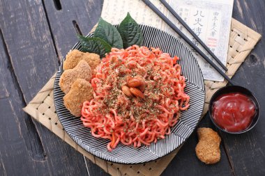 Sebze, nugget ve bademle kaplanmış baharatlı erişte.