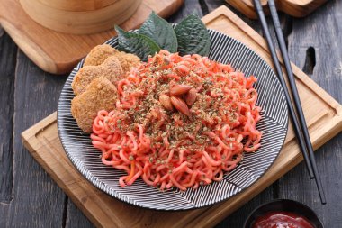 Sebze, nugget ve bademle kaplanmış baharatlı erişte.