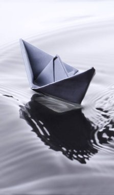 Suyun engebeli yüzeyinde kağıt tekne