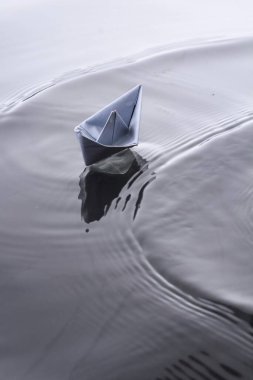 Suyun engebeli yüzeyinde kağıt tekne