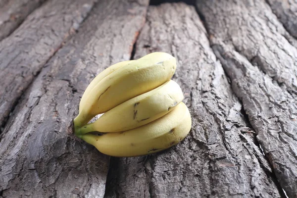 在木制的背景上把香蕉捆在一起 — 图库照片
