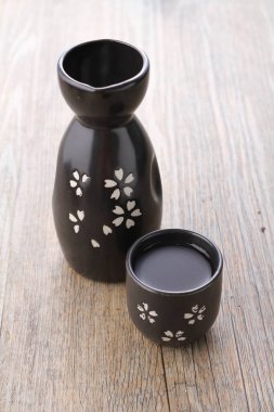 Bir fincan çay ve ahşap arka planda bir demlik.