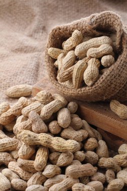 Kahverengi arka planda ahşap bir kasede yer fıstığı