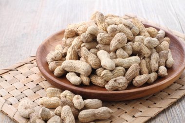 Tahta bir arka planda kasedeki fıstıklar.