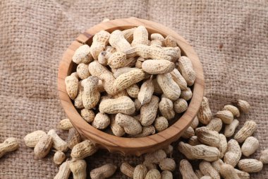 Tahta bir arka planda kasedeki fıstıklar.