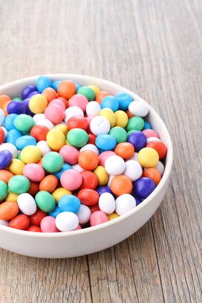 multicolored sweet candy in a bowl on a blue background