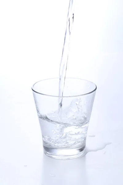 从一杯清澈的饮料中喷出的水 — 图库照片
