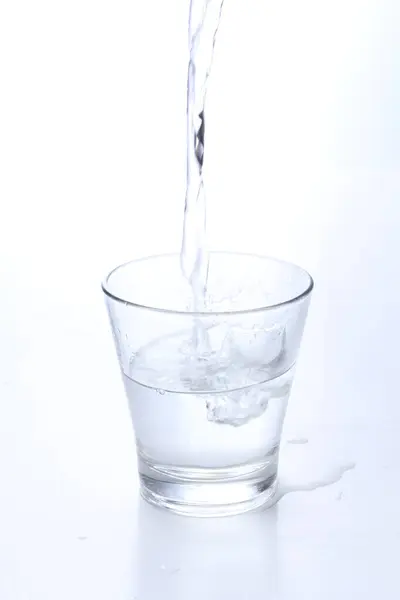 Nalewanie Wody Szklanki Białego Tła — Zdjęcie stockowe