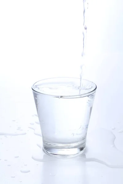 Bicchiere Acqua Con Versando Uno Spruzzo — Foto Stock