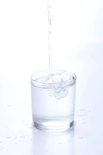 Menuangkan Air Dalam Gelas Dan Memercikkan Air Dalamnya — Stok Foto