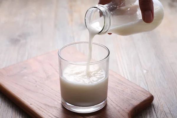 牛乳をガラスに注ぎ 新鮮で熟した白い背景のジャグを選択的に焦点を当てて — ストック写真