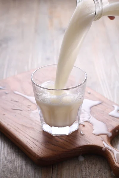 Milch Mit Einem Löffel Auf Einem Holztisch Ein Glas Gießen — Stockfoto
