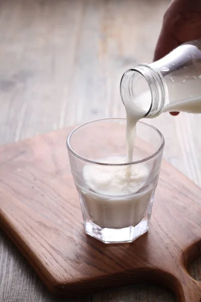 Hälla Vatten Ett Glas Mjölk Ett Träbord — Stockfoto