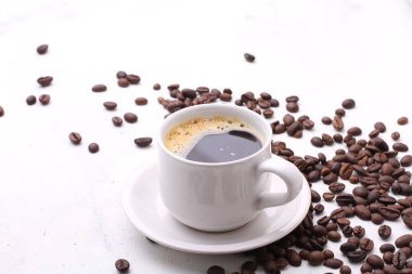 Beyaz arka planda kavrulmuş fasulye ile kahve fincanı