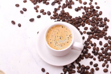 Beyaz arka planda bir fincan kahve ve fasulye, seçici odak