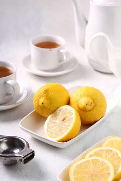 stock image lemon tea in cup and teapot on white table