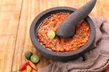 Ahşap arka planda bir tavada kırmızı biber