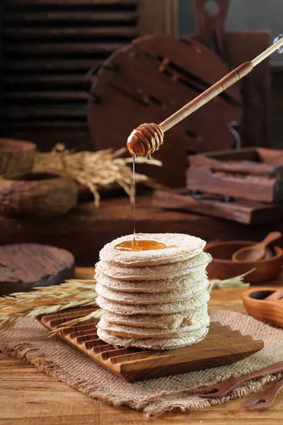 带有蜂蜜和巧克力的木制背景自制煎饼 — 图库照片